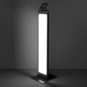 Photo en studio du support de sol noir Compulocks BrandMe Lumina VESA, vu en diagonale de face avec la bande LED éclairée dans un environnement sombre.